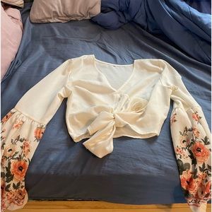 A floral blouse with flowers on the side of the sleeves.